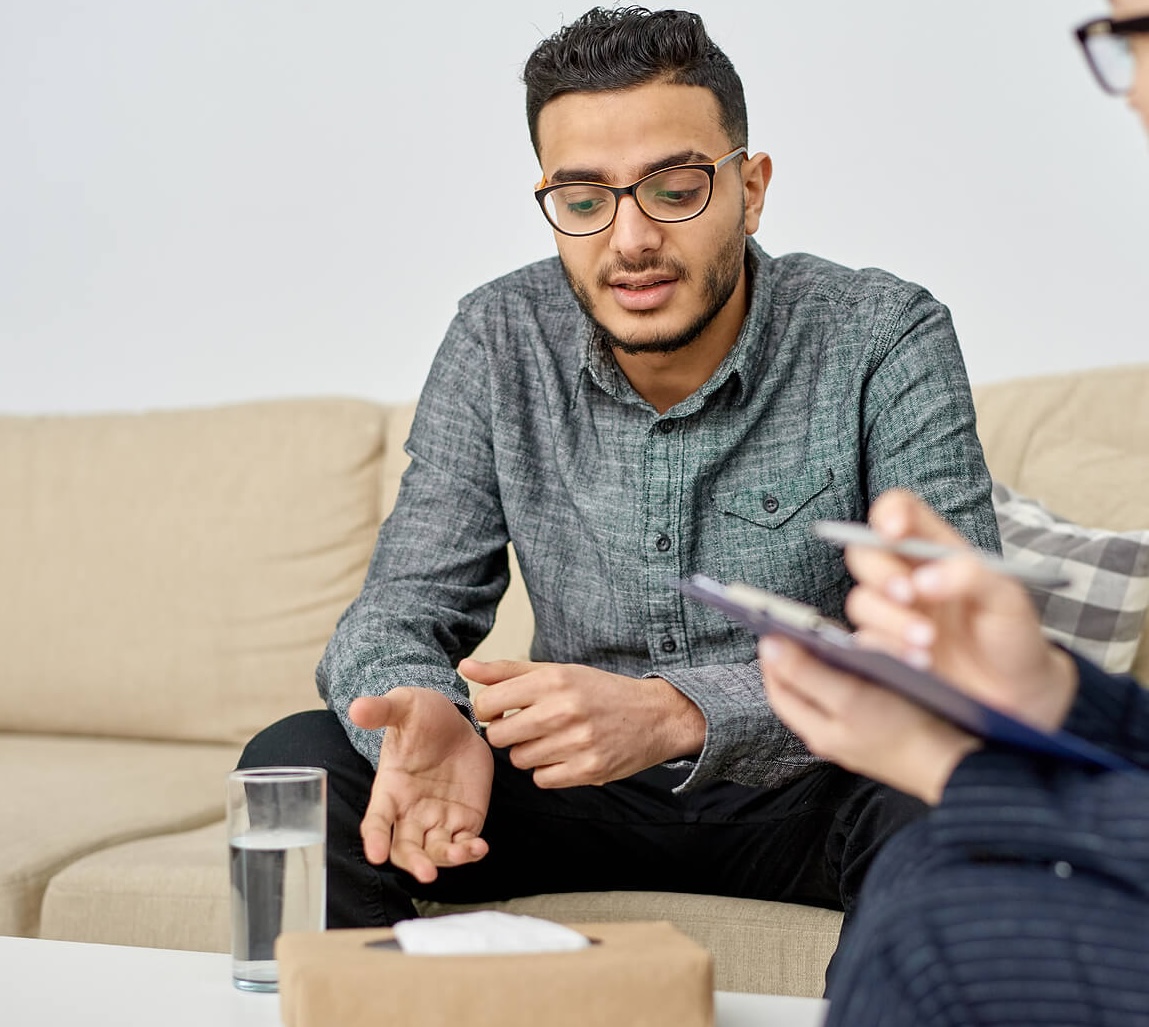 A man talking with a therapist during a counseling session, representing the healing and self-awareness that can come from men’s therapy in Mount Pleasant, WI.