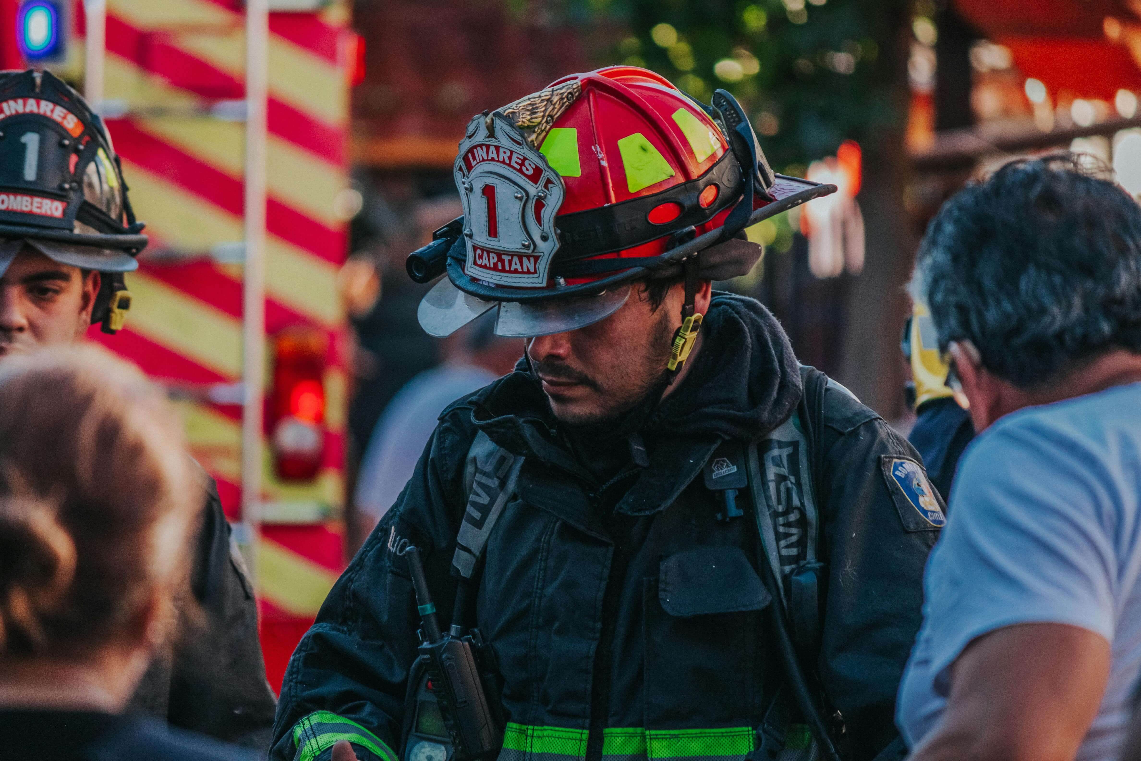Firefighter in full gear and helmet looking down during an emergency scene. Find lasting relief from flashbacks and emotional shutdown with men's therapy in Milwaukee, WI.